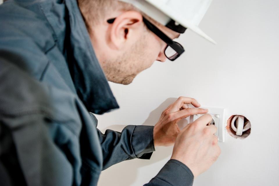 Elektrikář instaluje zásuvku ve zdi
