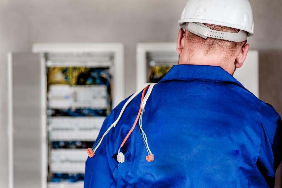 Technik v přilbě u rozvodných skříní