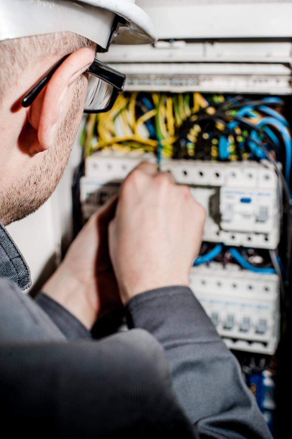 Elektrikář zapojuje vodiče v rozvaděči